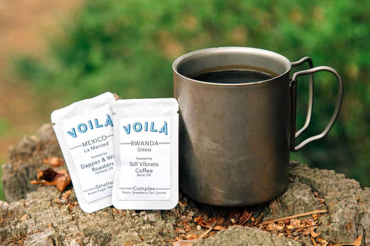 Voila, eine Instantkaffeeverpackung neben einem Campingbecher