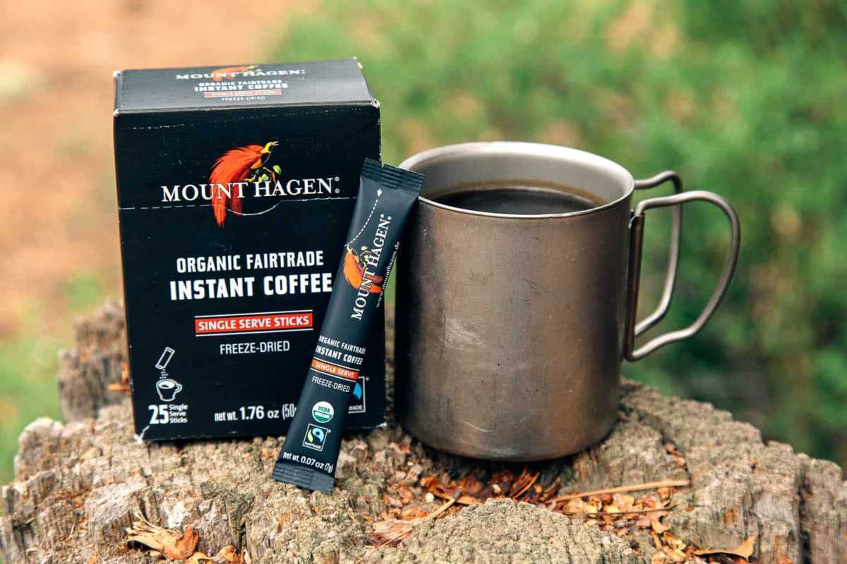 Embalagem de café instantâneo Mount Hagen ao lado de uma caneca de acampamento