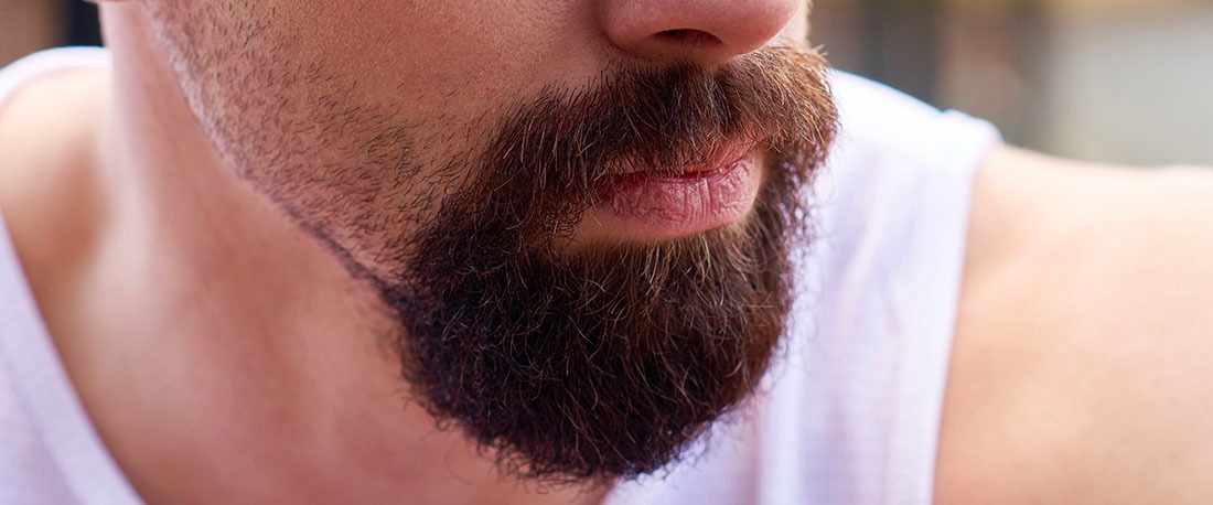 En skallig man med full cirkel skägg och mustasch