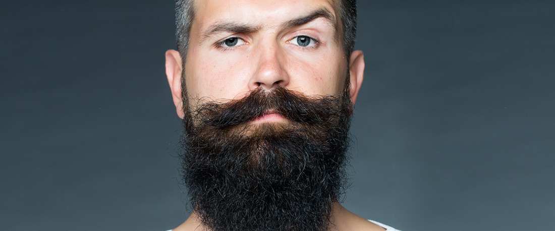 Jeune homme avec une barbe Viking et une moustache de guidon