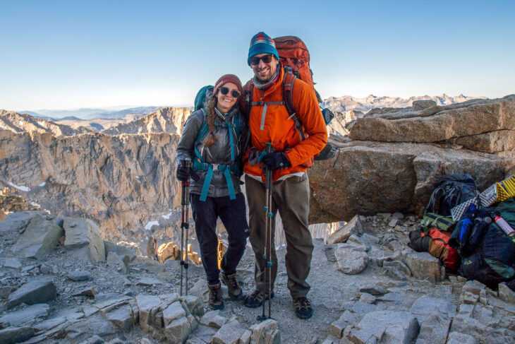 Megan und Michael tragen ihre Rucksackausrüstung mit Bergen in der Ferne
