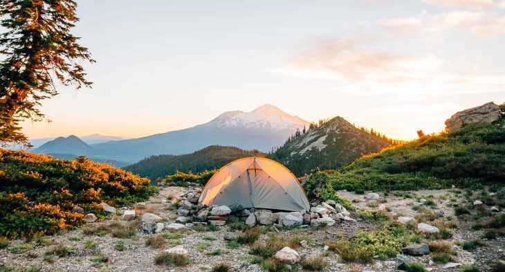 Туристическа палатка с планина на заден план