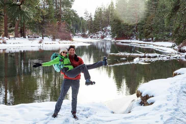 Megan dan Michael dengan perlengkapan hiking musim dingin mereka bersorak di depan kamera