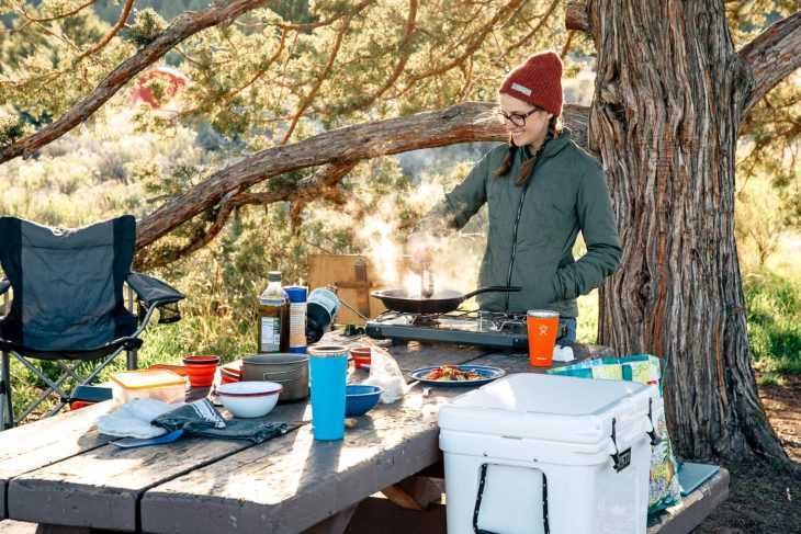 キャンプ場でキャンプ用ストーブで料理をするミーガン