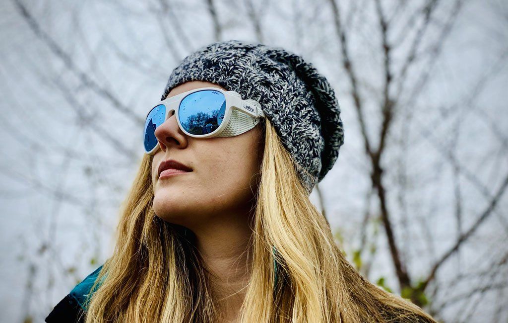 очила за ледник Revo, носени от жена в сняг