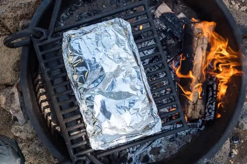   Un paquet d'aluminium sur un feu de camp