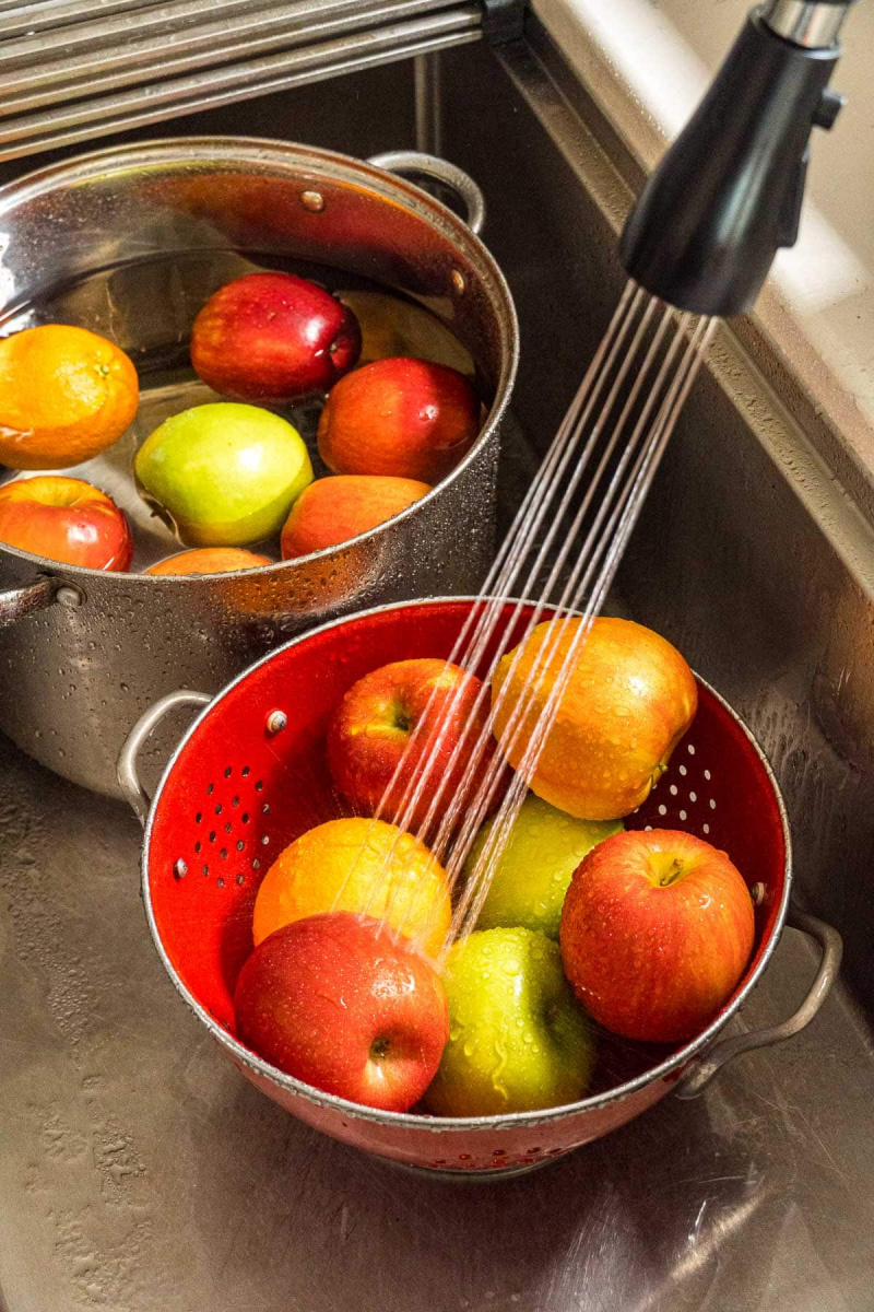   Laver les pommes dans une passoire rouge.