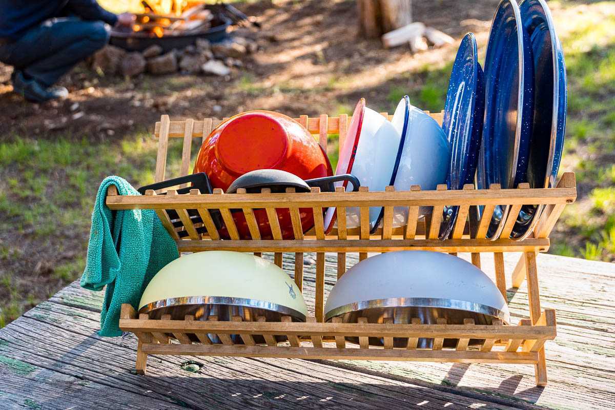 Curățați vasele de camping pe un suport de uscare