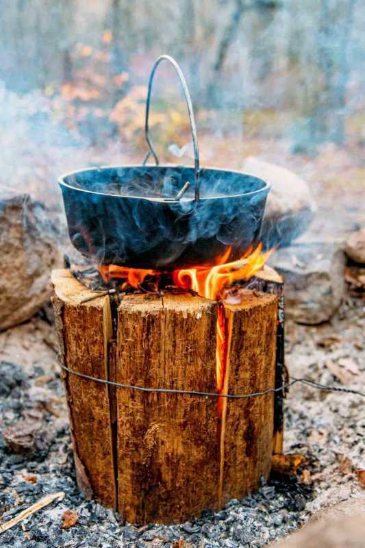 İsveçli bir ateş kütüğünün tepesinde duran bir Hollanda fırını