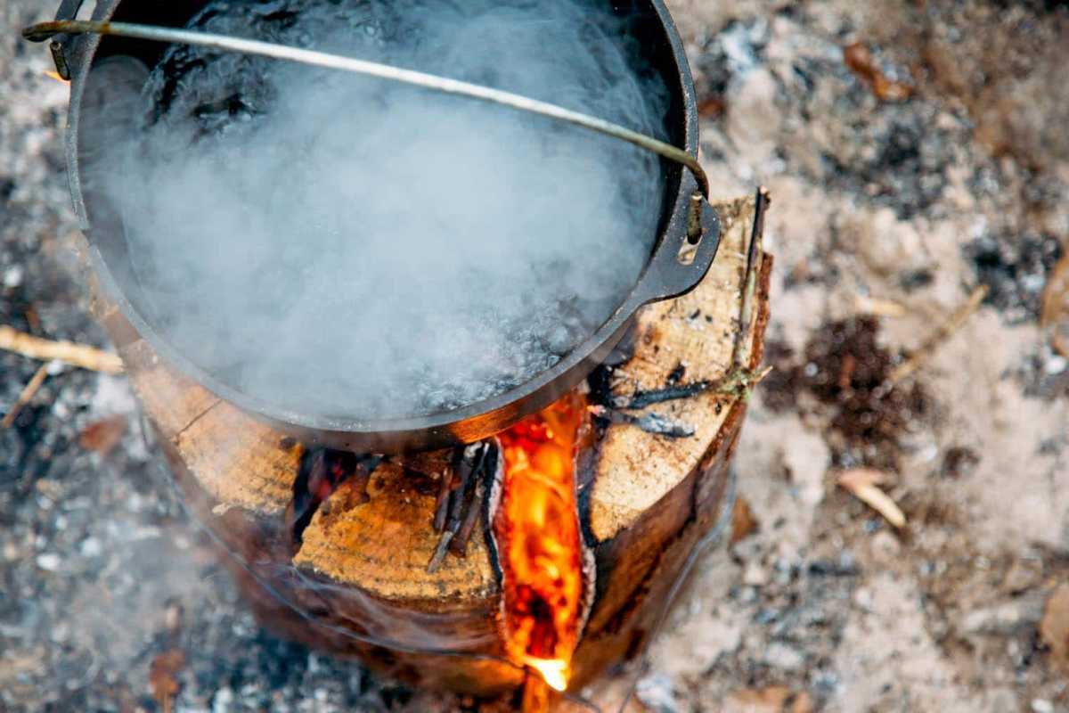 Ketuhar Belanda dengan air mendidih di atas kayu api Sweden