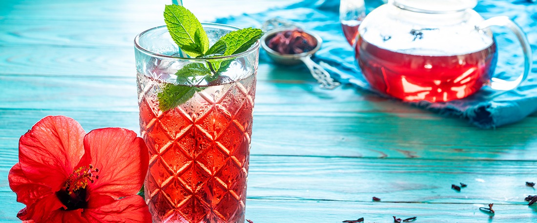 hibiscus-cocktail i et glass og tekanne