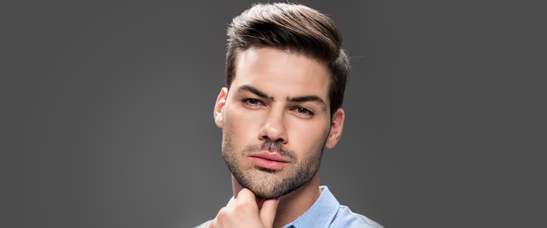 Kúpos oldalú, rövid tüskés frizurával rendelkező fiatalember