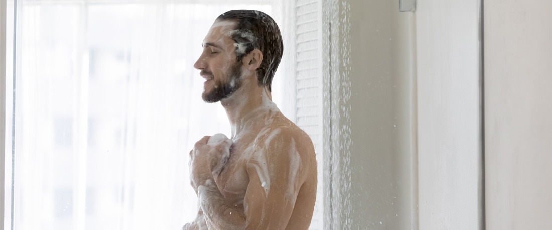 Un hombre tomando una ducha de agua caliente.