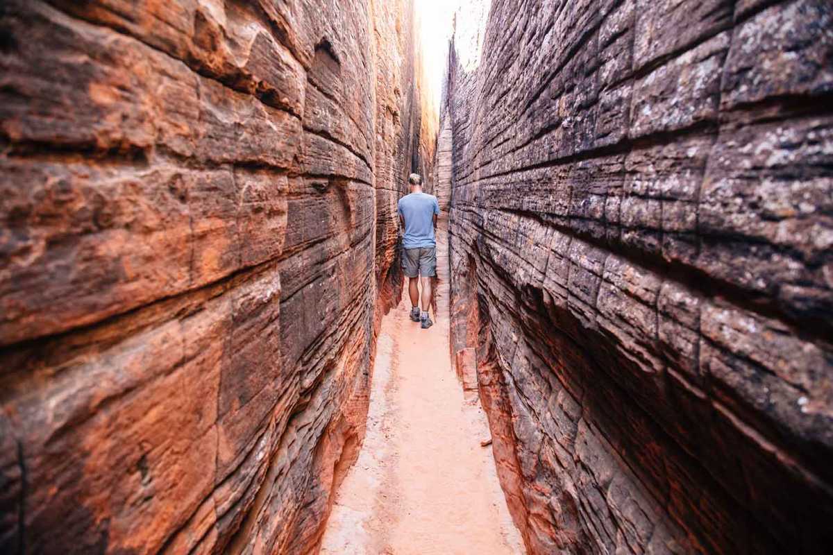 Michael cammina attraverso uno slot canyon contenente petroglifi