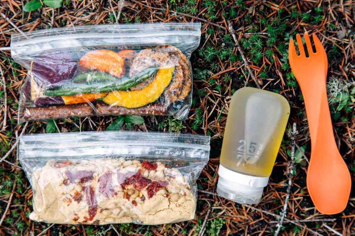 Ingredienser til backpacking af hummus i ziplock-poser på en skovbund.