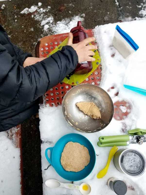 Roti-Teig auf einem kleinen Schneidebrett auf einem verschneiten Tisch rollen