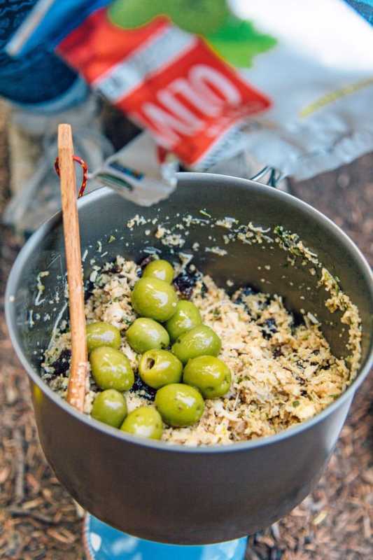 En tresleiv i en gryte som er fylt med couscous og grønne oliven