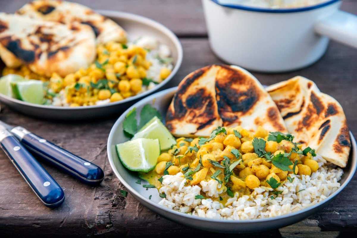 Curry de grão de bico com arroz em um prato de acampamento.