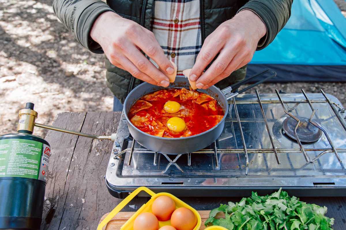 チラキレスは簡単なキャンプ朝食のアイデアです。スパイシーなトマトソースで煮込んだカリカリのトルティーヤに卵をトッピングしたものです。作るのに30分もかからないので、
