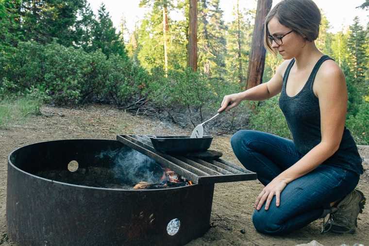 Megan používa liatinovú panvicu na varenie nad táborákom