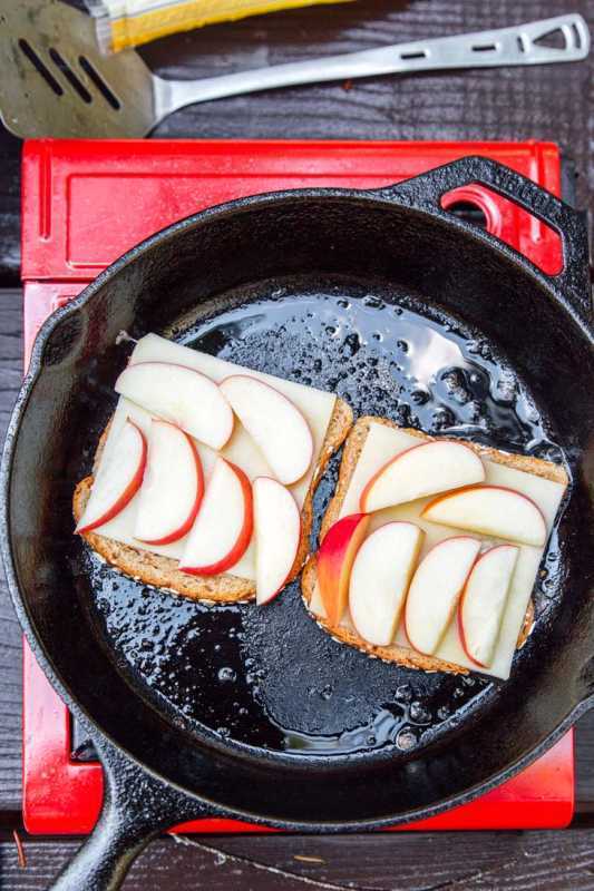 Pa amb capes de formatge i pomes a rodanxes en una paella