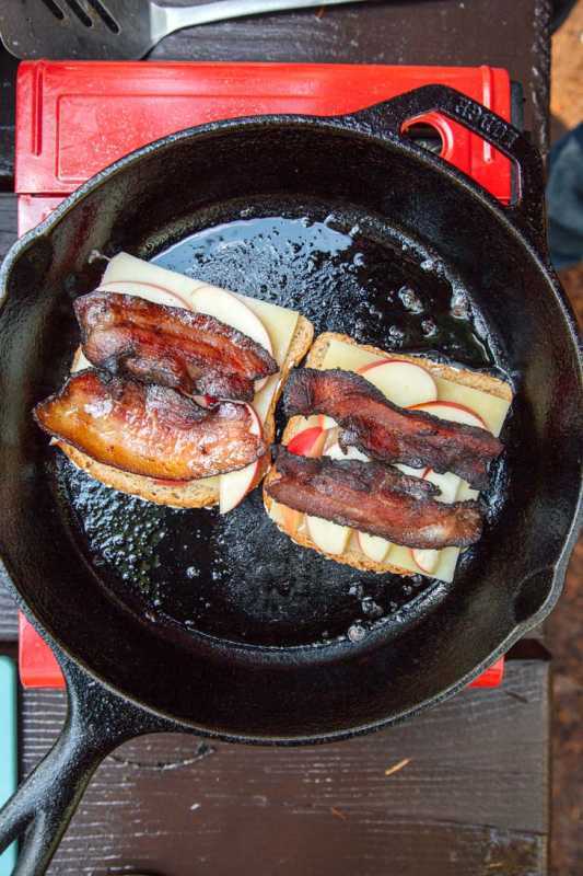 Roti berlapis keju dan bacon goreng dalam wajan