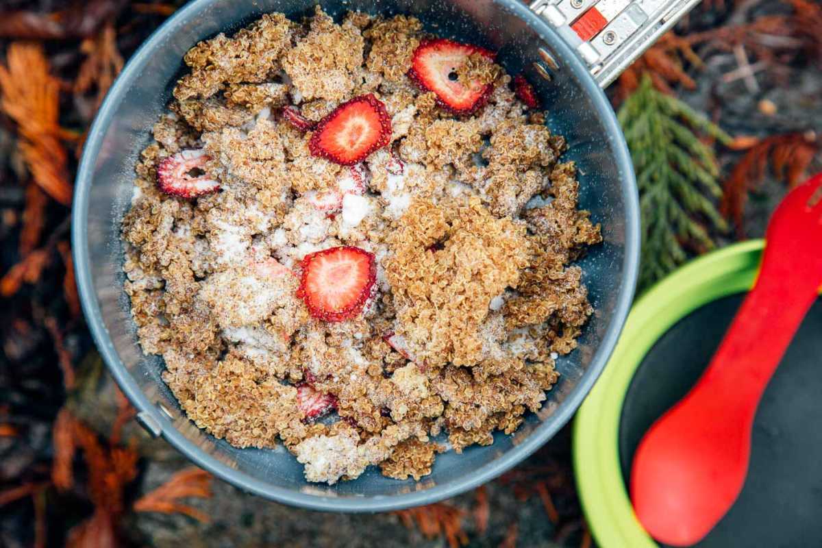Erdbeeren und Sahne-Quinoa-Porridge in einem Rucksacktopf