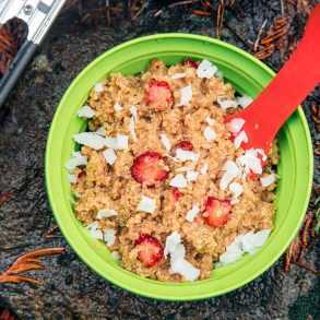 Erdbeeren und Sahne-Quinoa-Porridge in einer Schüssel auf einem Felsen