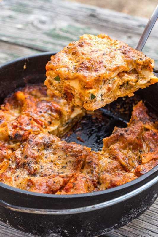 Mengangkat sekeping lasagna daripada ketuhar Belanda