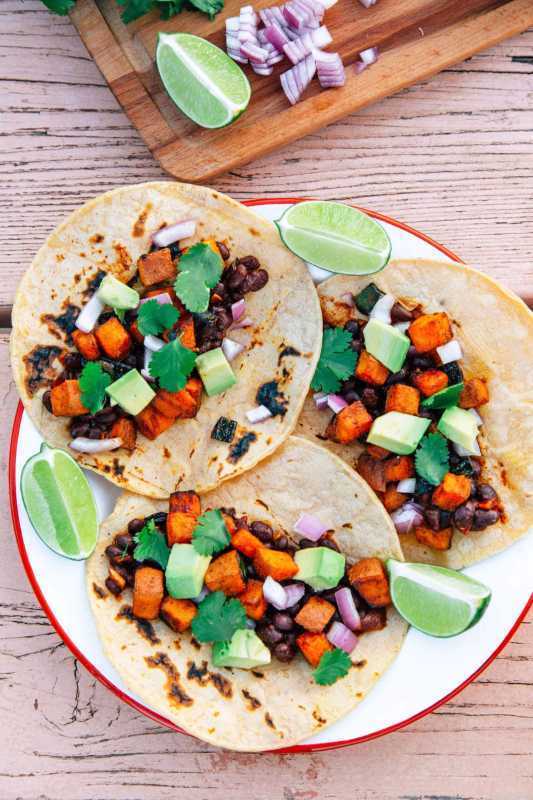 Tre sötpotatis och svarta bönor tacos på en tallrik