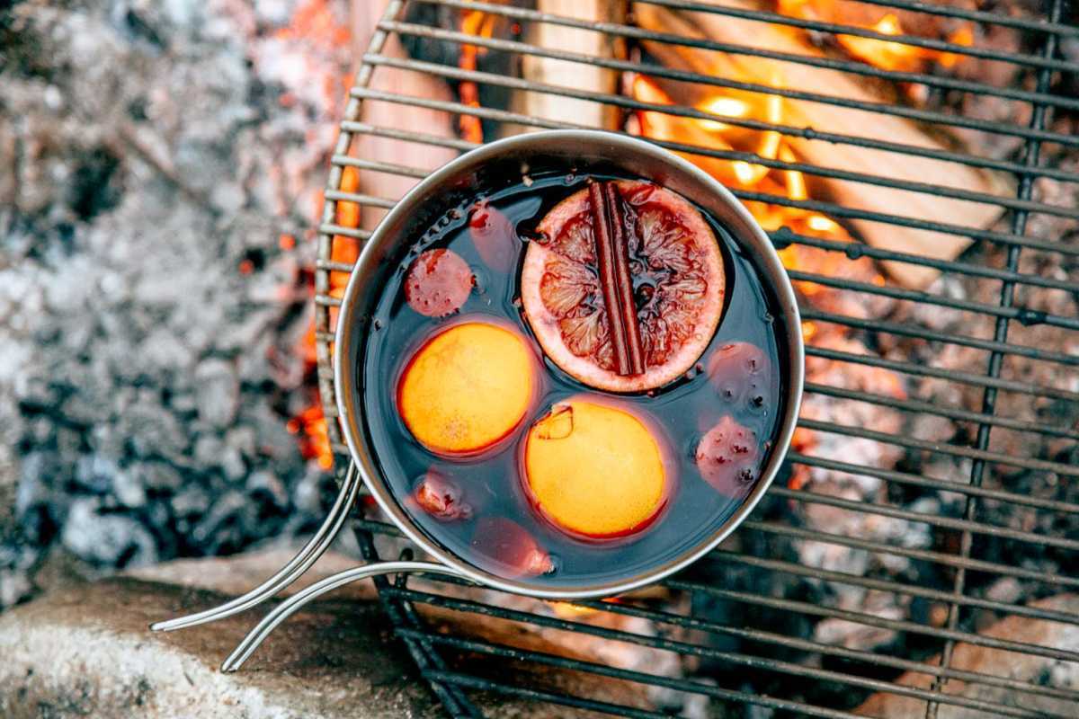 Vin chaud mijoté dans une casserole sur un feu de camp