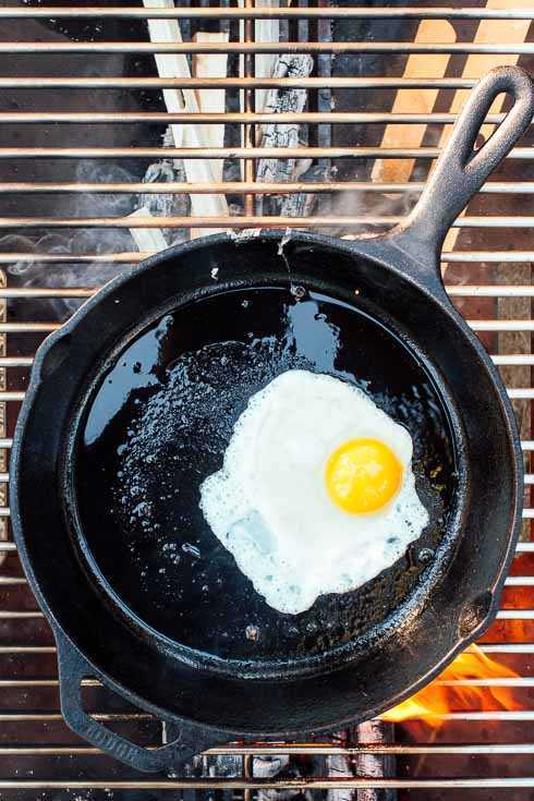Huevo soleado en una sartén de hierro fundido sobre una fogata
