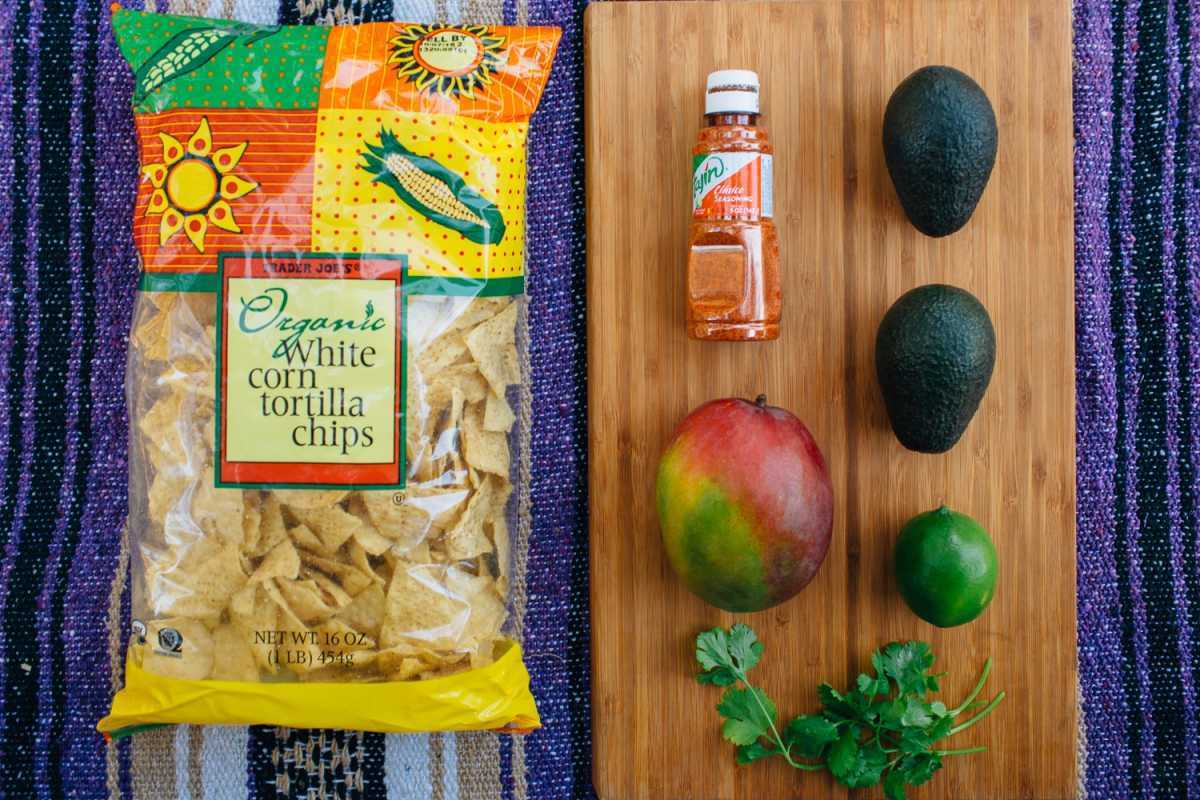 Ingrediente pentru guacamole de mango așezate pe o masă de tăiat