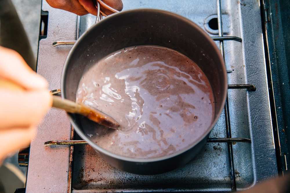 Michael navlékl hrnec horké čokolády na táborový vařič