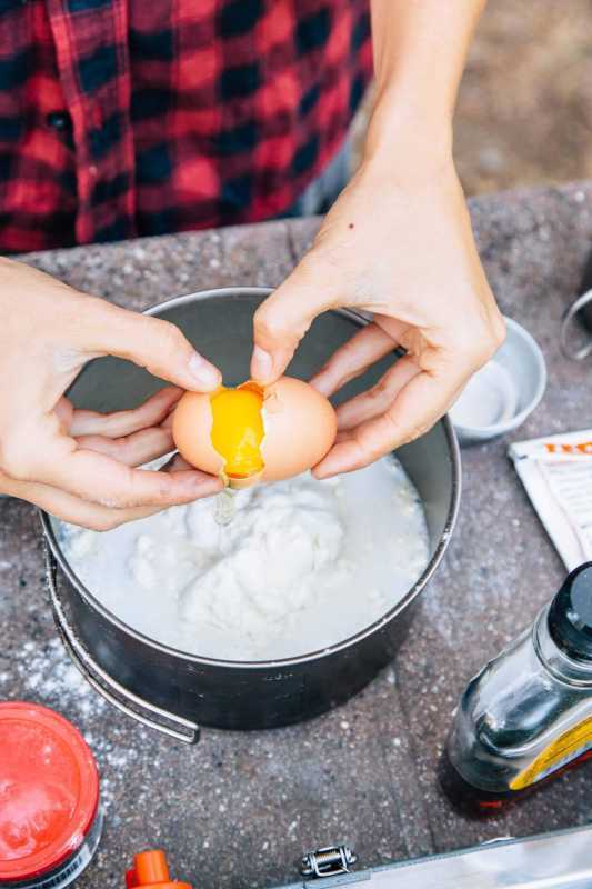 Megan knäcker ett ägg i en kastrull full med mjöl