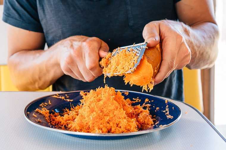 Michael utilitza un ratllador de formatge per tallar un moniato