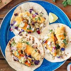 Drei Fisch-Tacos auf einem blauen Teller