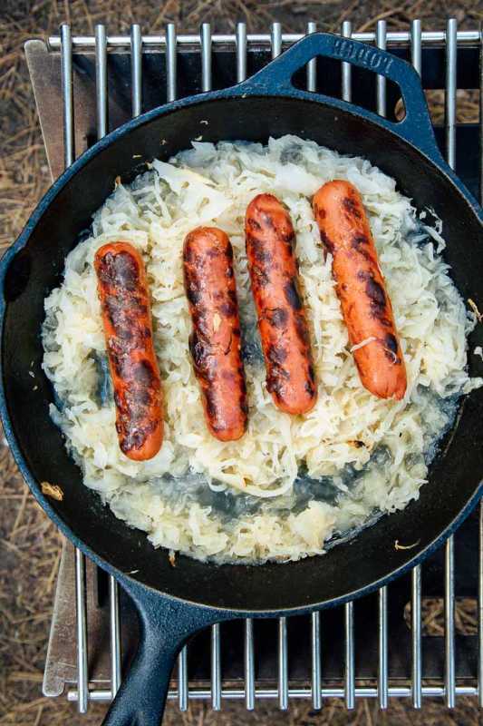 En stegepande med surkål og grillede hotdogs