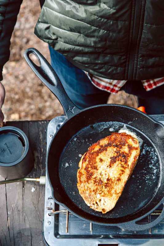 En stabel pannekaker med kanel-epletopp på en blå campingplate.