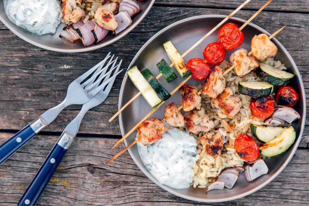 Grillezett csirke és zöldség nyárs tzatziki szósszal egy tányéron
