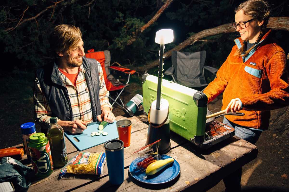 ランタンの明かりを灯したキャンプ用ストーブで料理をするミーガンとマイケル