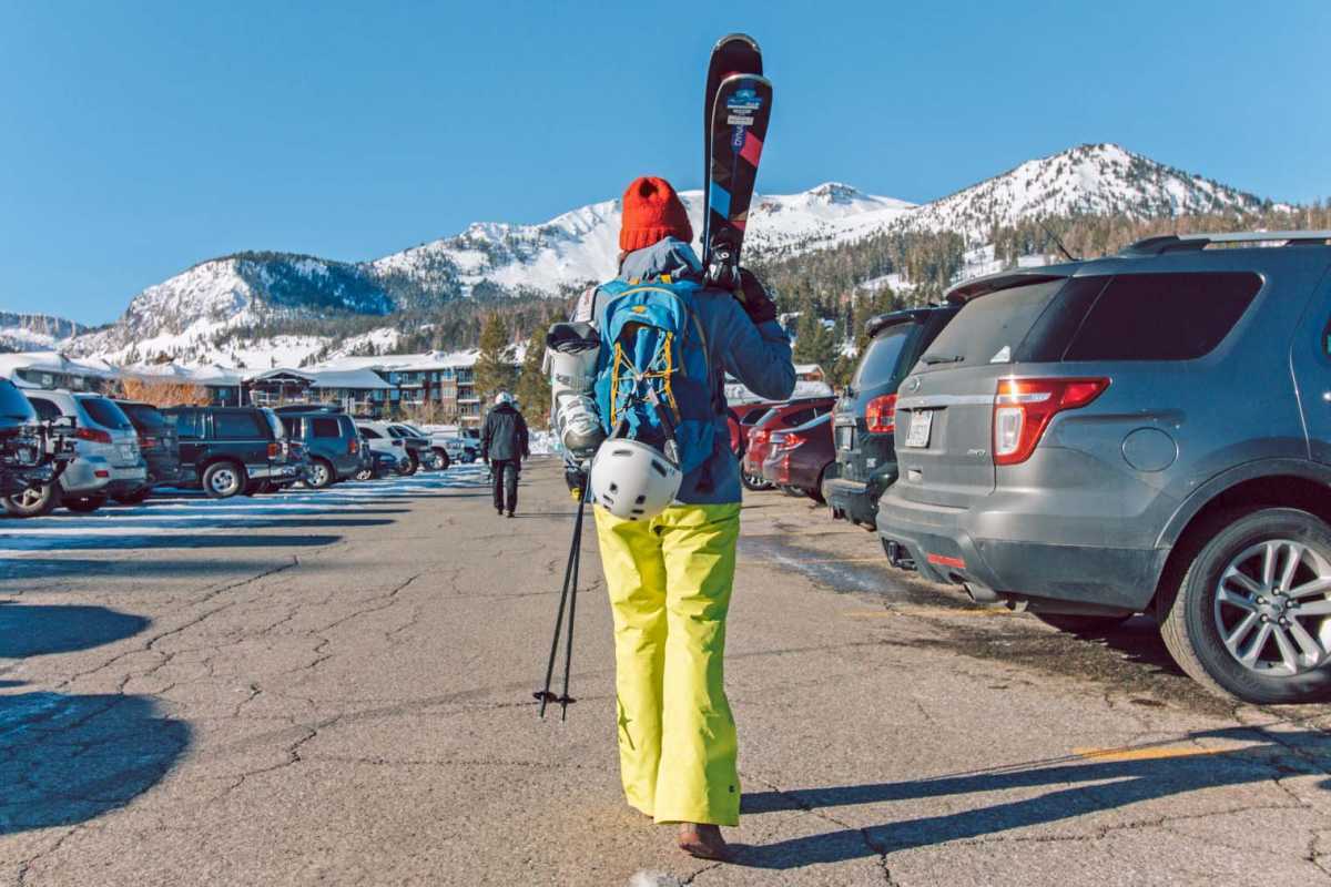 Si Megan na may dalang ski sa isang parking lot