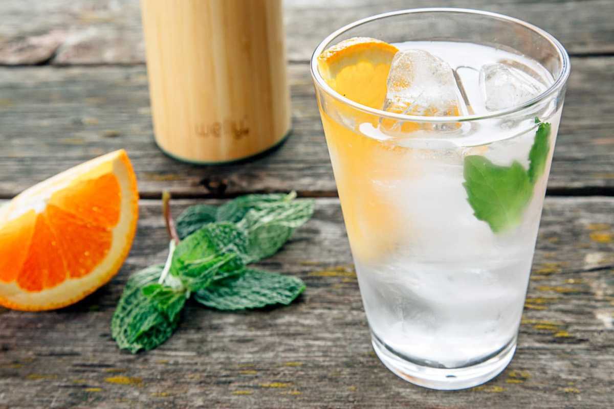 Infundert vann med appelsiner og mynte i et høyt glass.