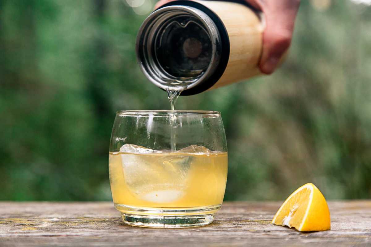 Een esdoorn-goudkoortscocktail in een glas gieten,