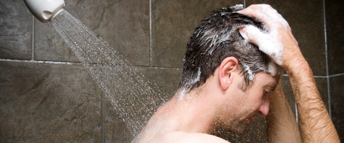 õnnelik mees puhastab juukseid šampooniga